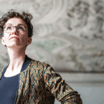 Verena Smit betrachtet die Stuckdecke eines historischen Gebäudes.